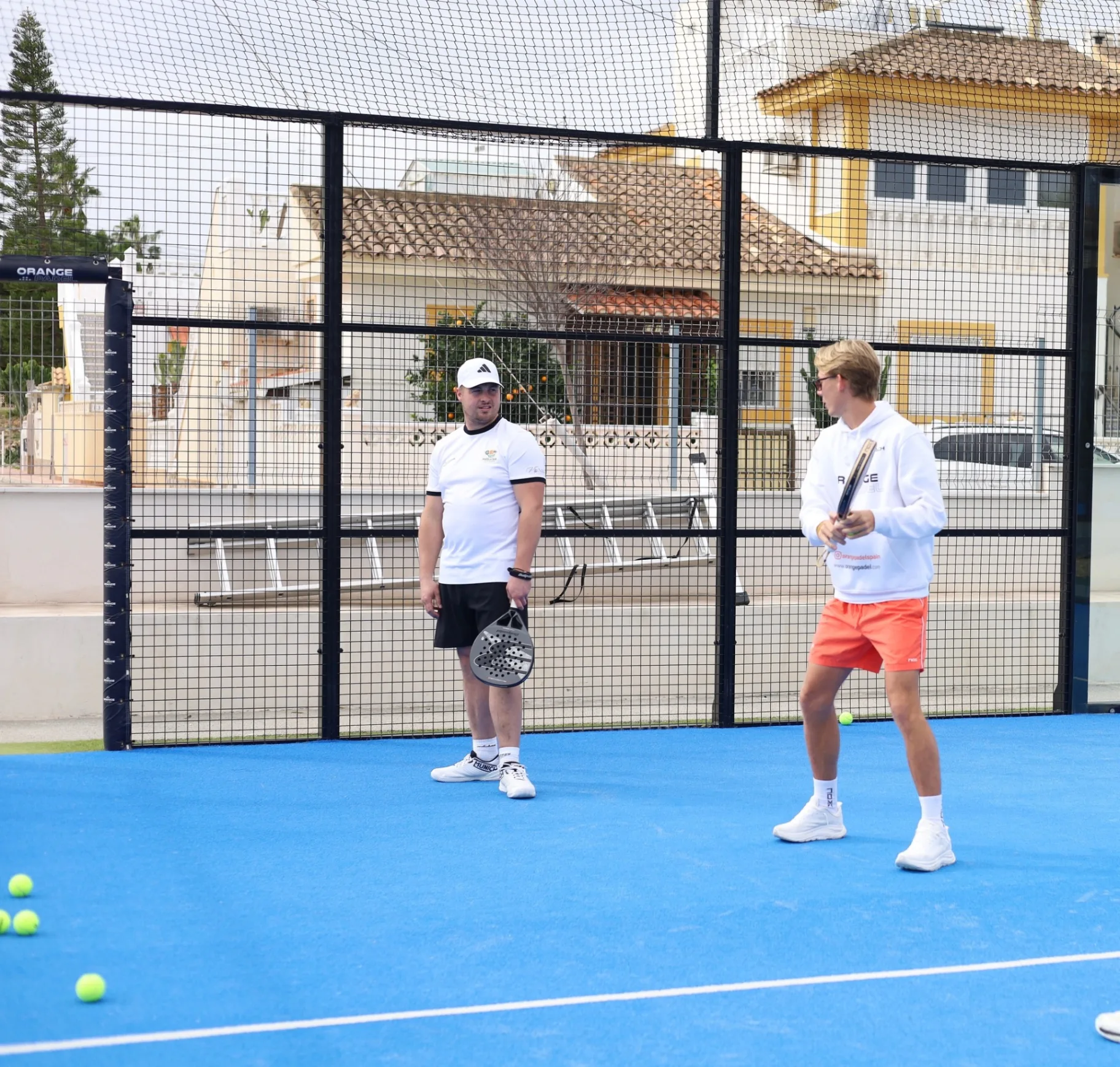 Padelcoach geeft training aan een speler op de baan